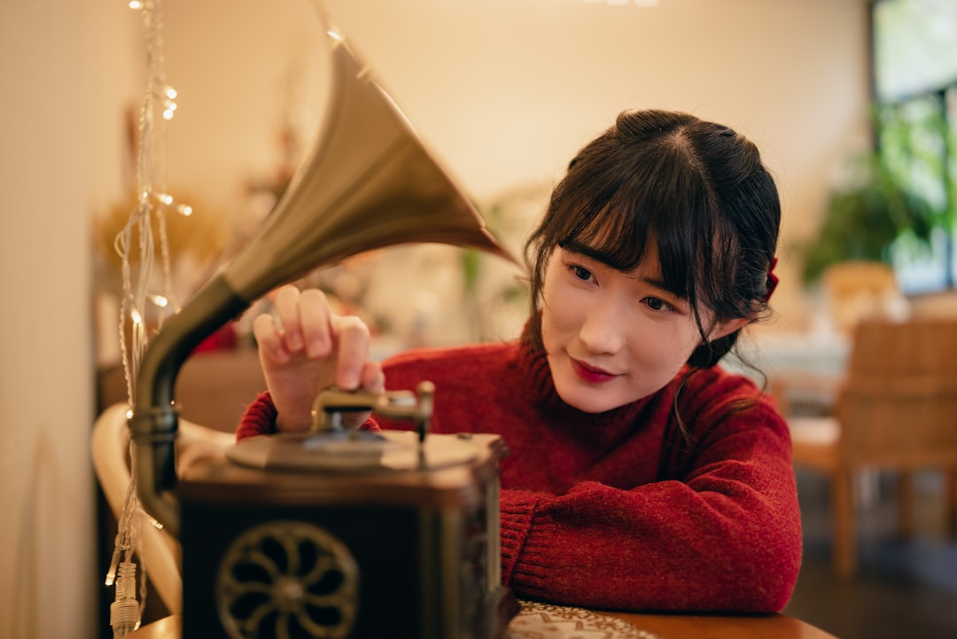 a young girl sitting at a table with a record player,