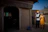 A happy couple standing in front of their new Jaipur home with traditional architecture.