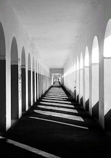 a black and white photo of a long hallway
