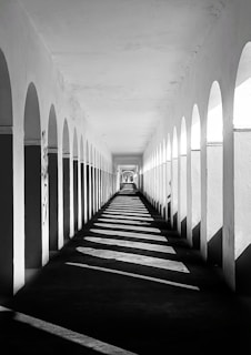 a black and white photo of a long hallway