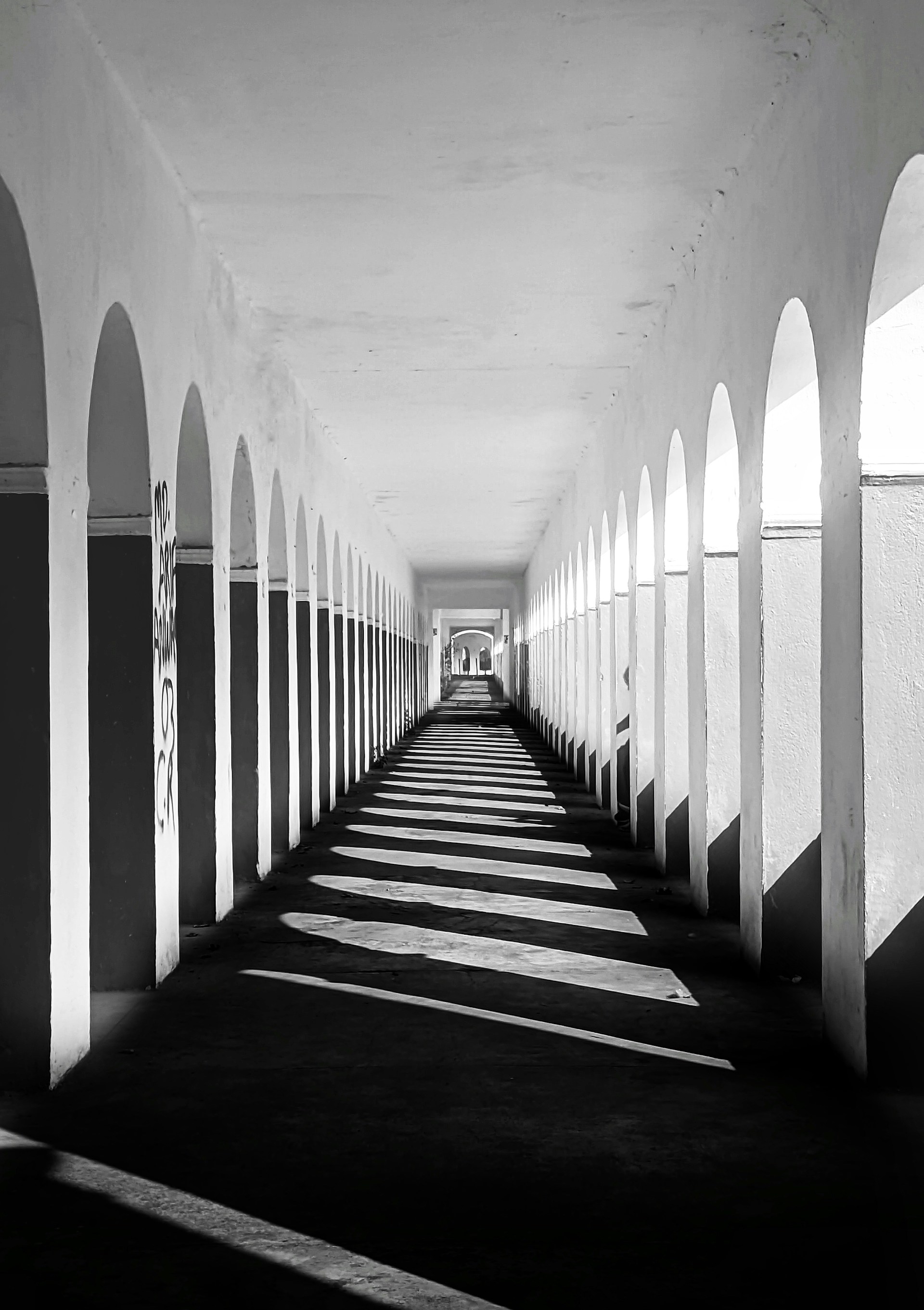 a black and white photo of a long hallway