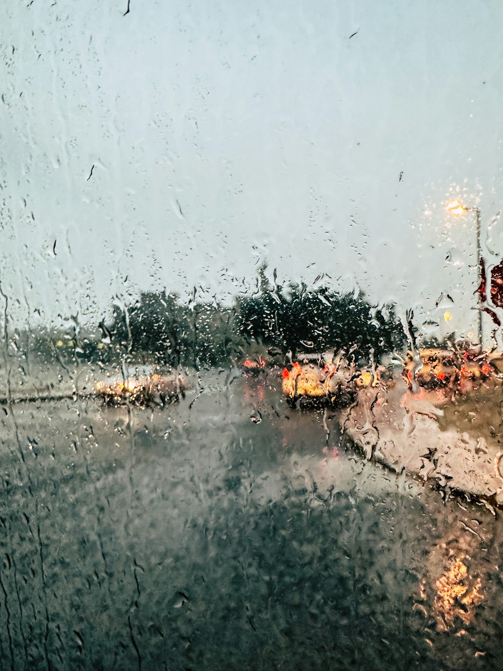 a view of a street through a rain covered window