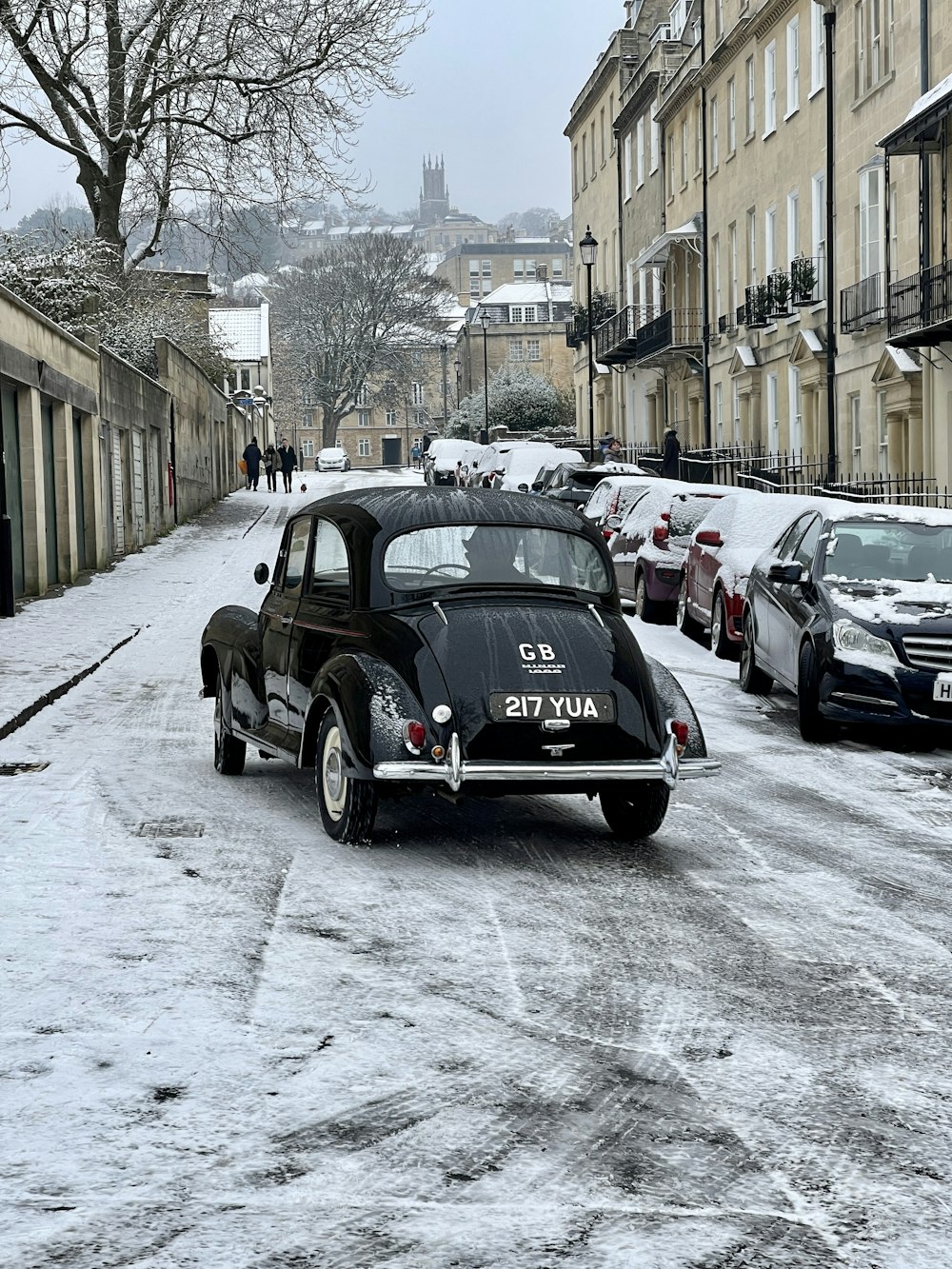 a black car is parked on a snowy street