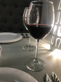 Elegant wine glasses filled with red and white wine on a candlelit table