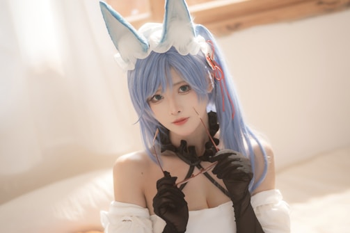 A person with long blue hair, wearing fox-like ears and a headpiece, is dressed in a black and white outfit with gloves. The setting is softly lit, creating a dreamy atmosphere.