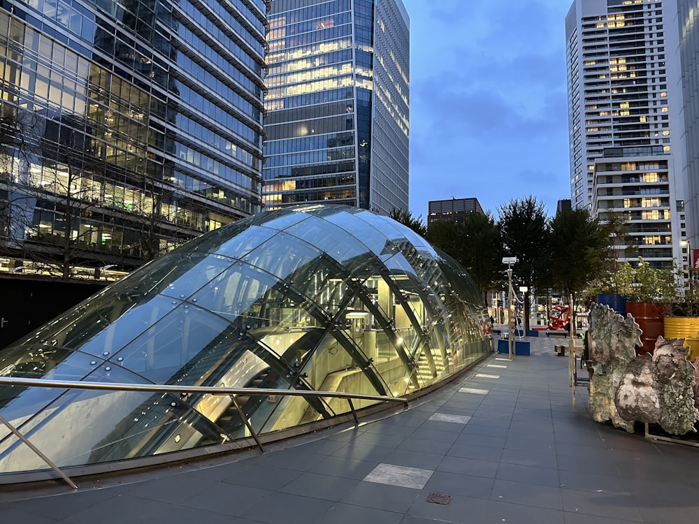 a glass covered walkway in a city at dusk