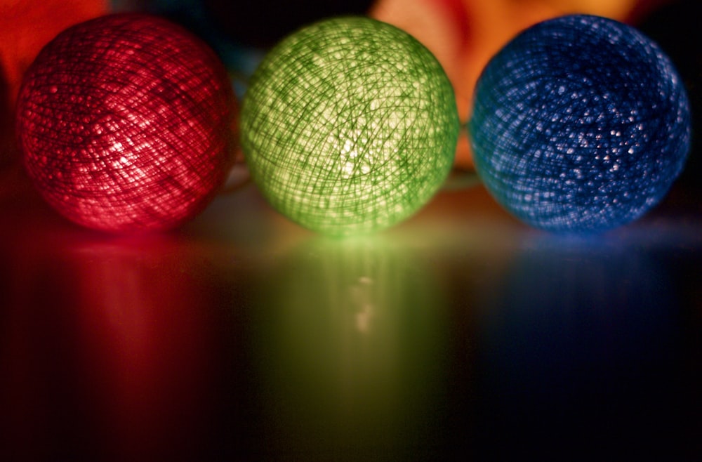 three brightly colored balls sitting on top of a table