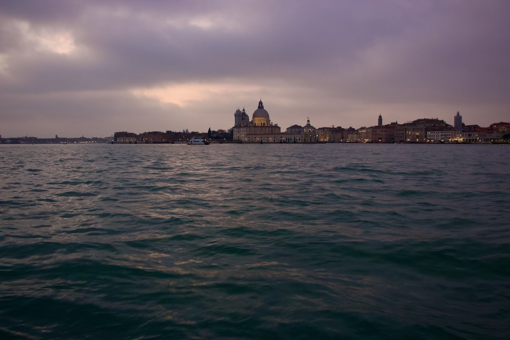 a large body of water with buildings in the background