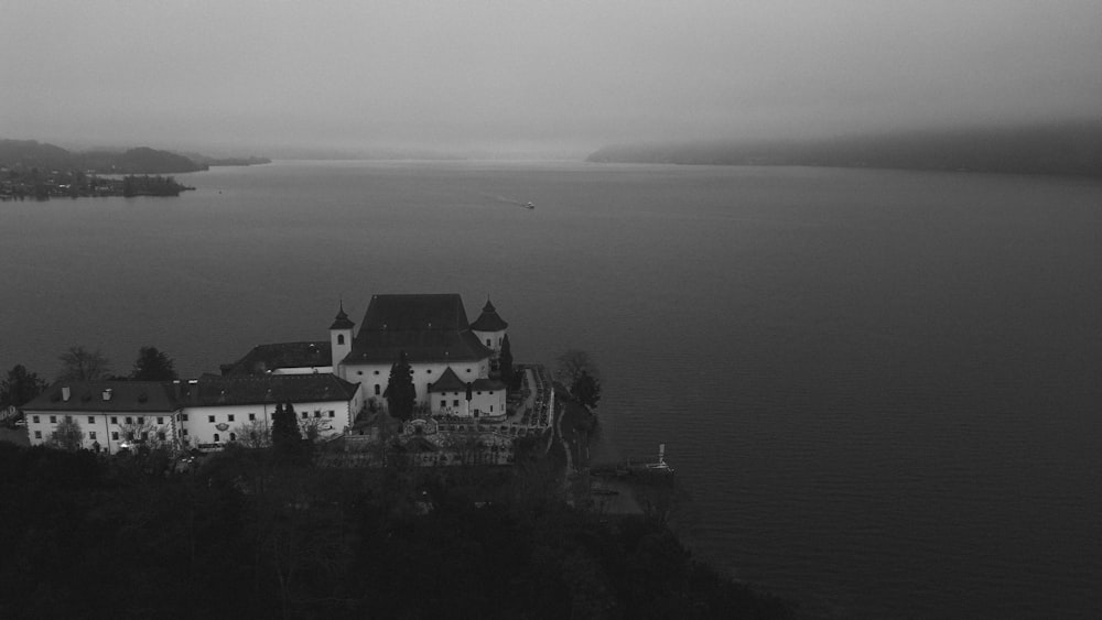 a black and white photo of a castle in the middle of a lake