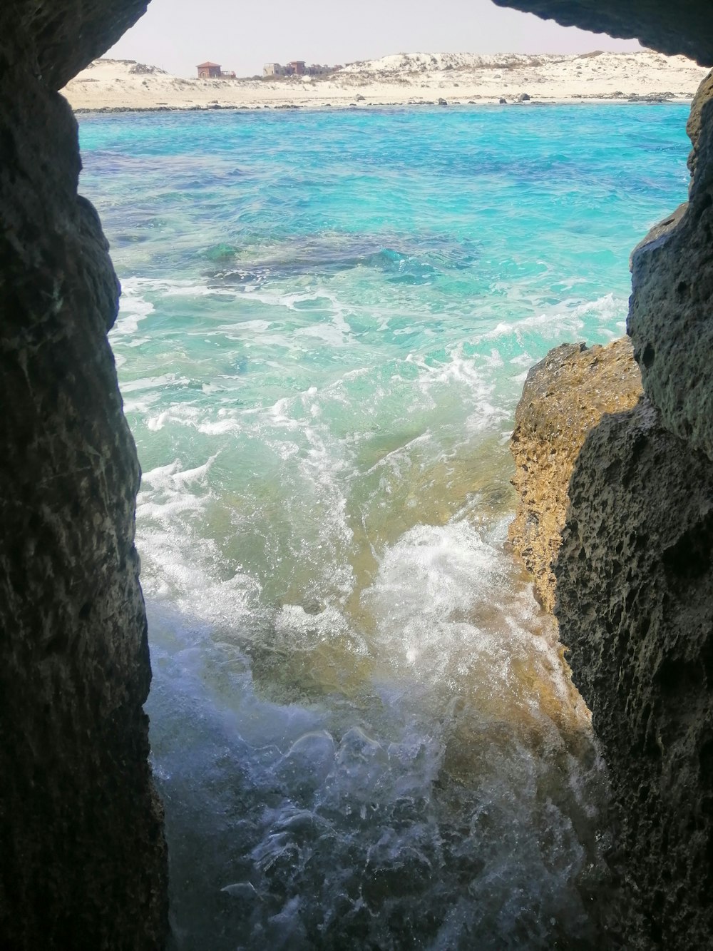 a view of a body of water from inside a cave