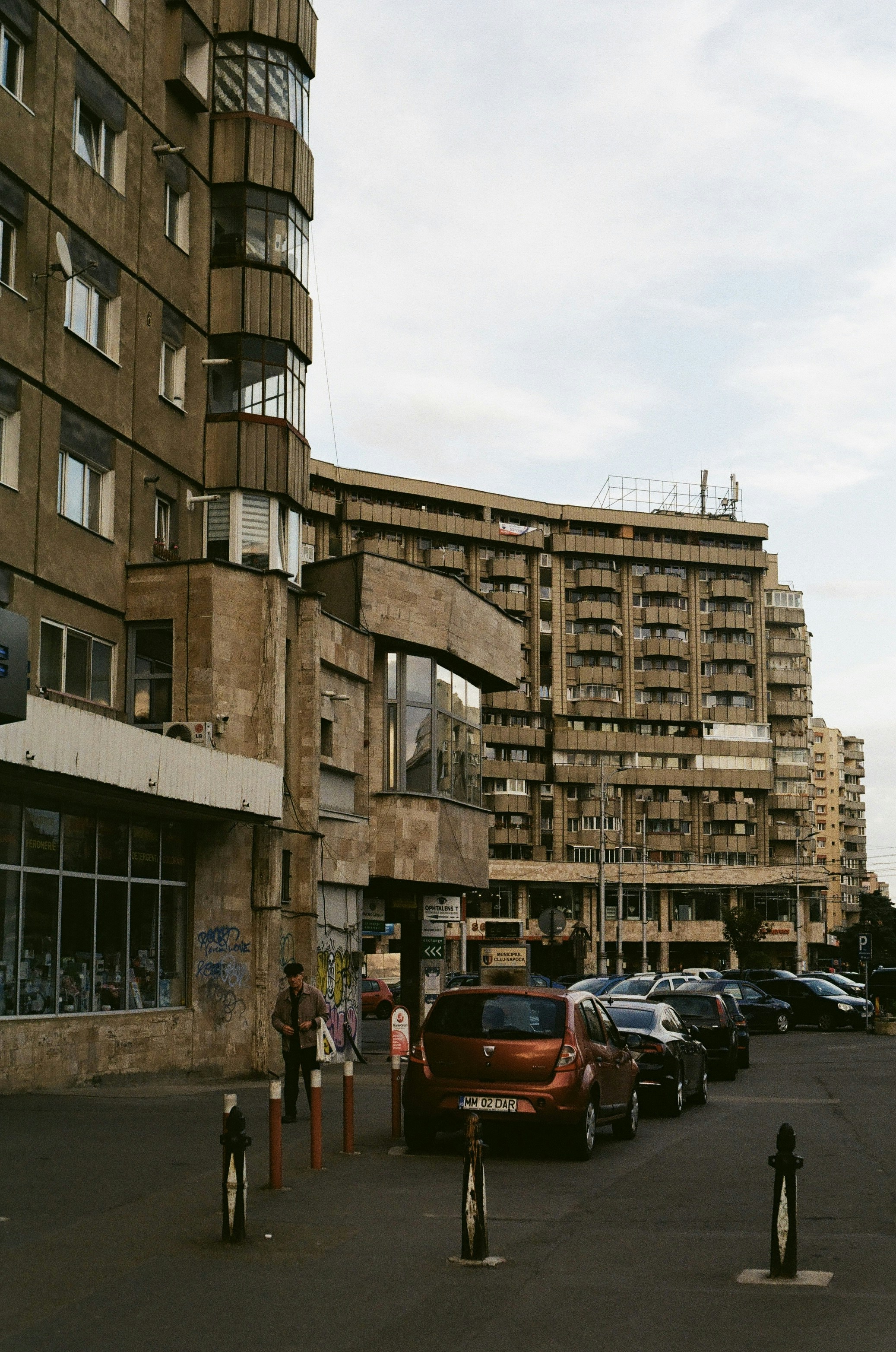 cars parked in a parking lot in front of a tall building