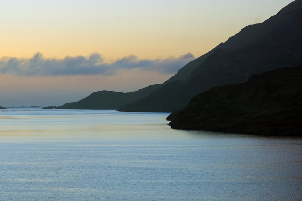 a large body of water with mountains in the background