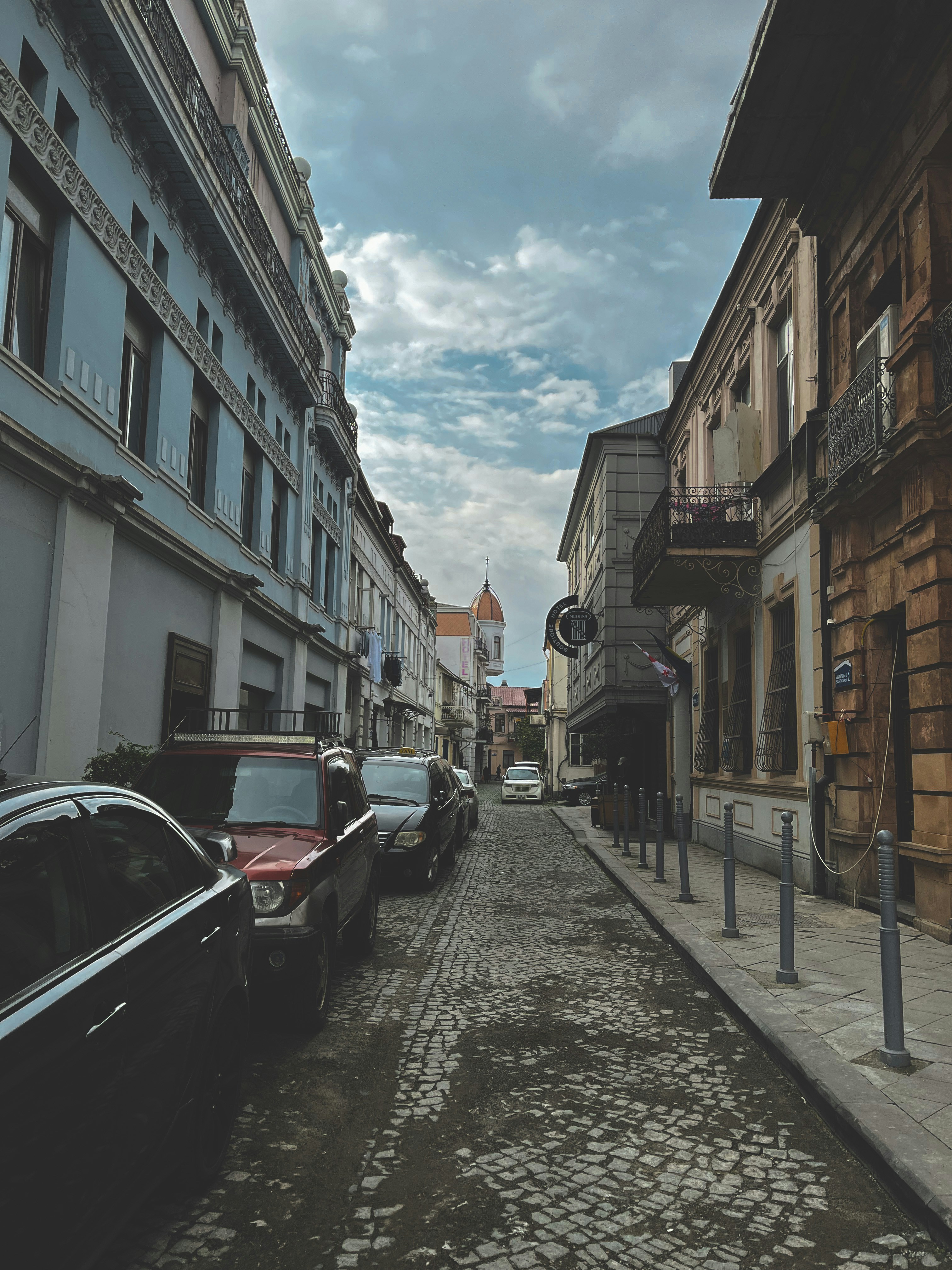 a street lined with parked cars next to tall buildings