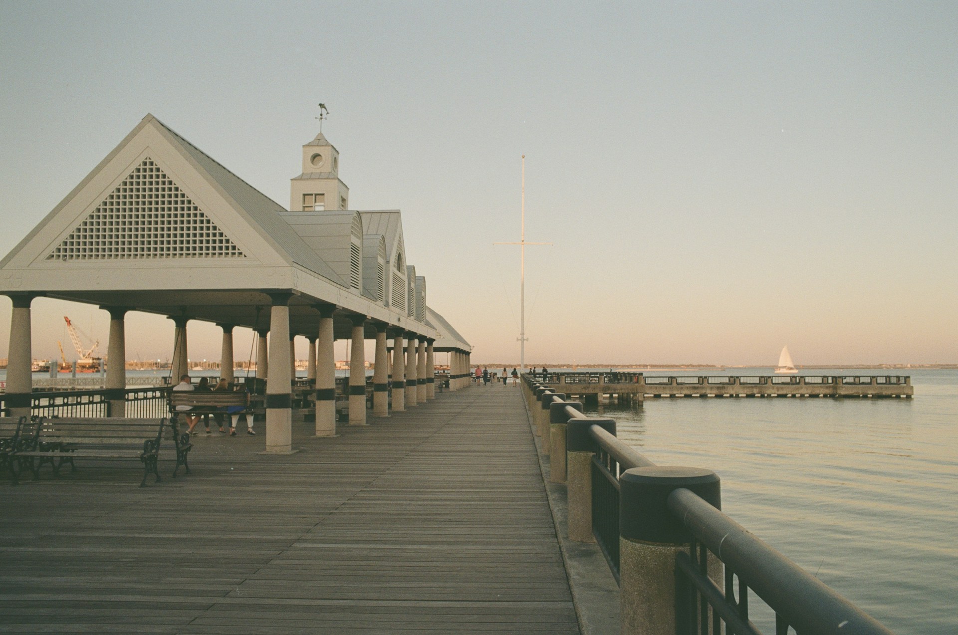 a pier with benches and a clock tower in the background