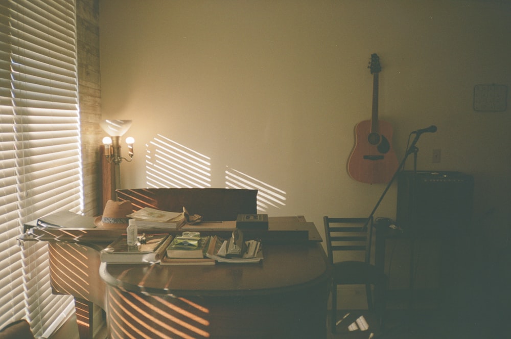 a room with a guitar and a desk in it