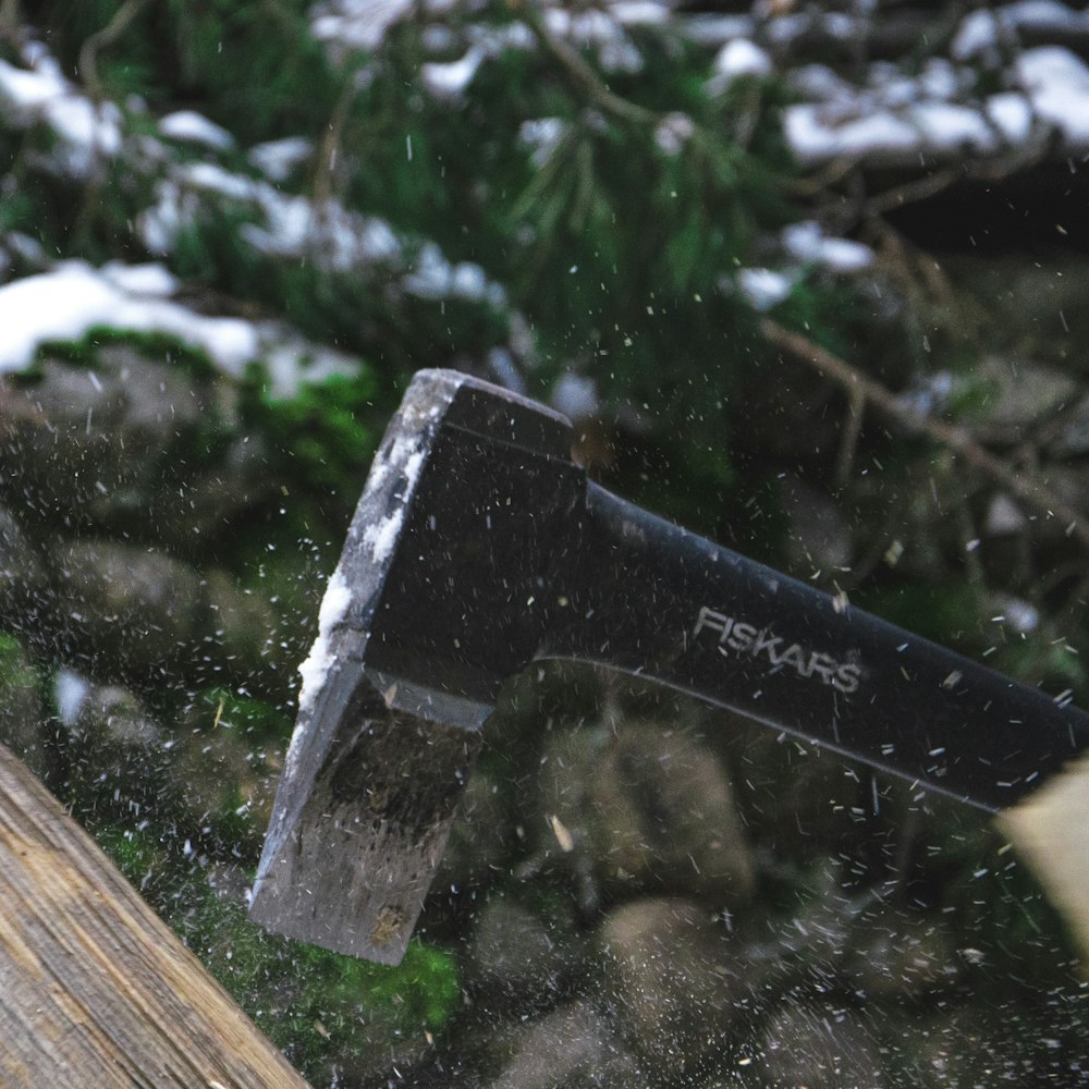 a hammer hitting a piece of wood in the snow