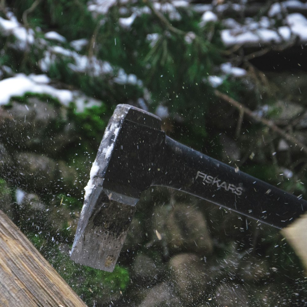 Ein Hammer schlägt auf ein Stück Holz im Schnee