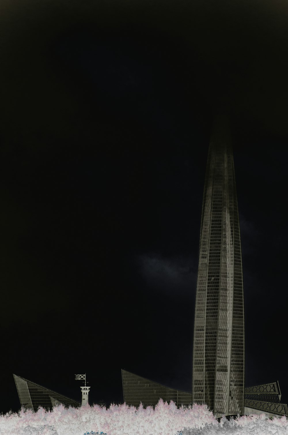 a very tall building in the middle of a dark sky