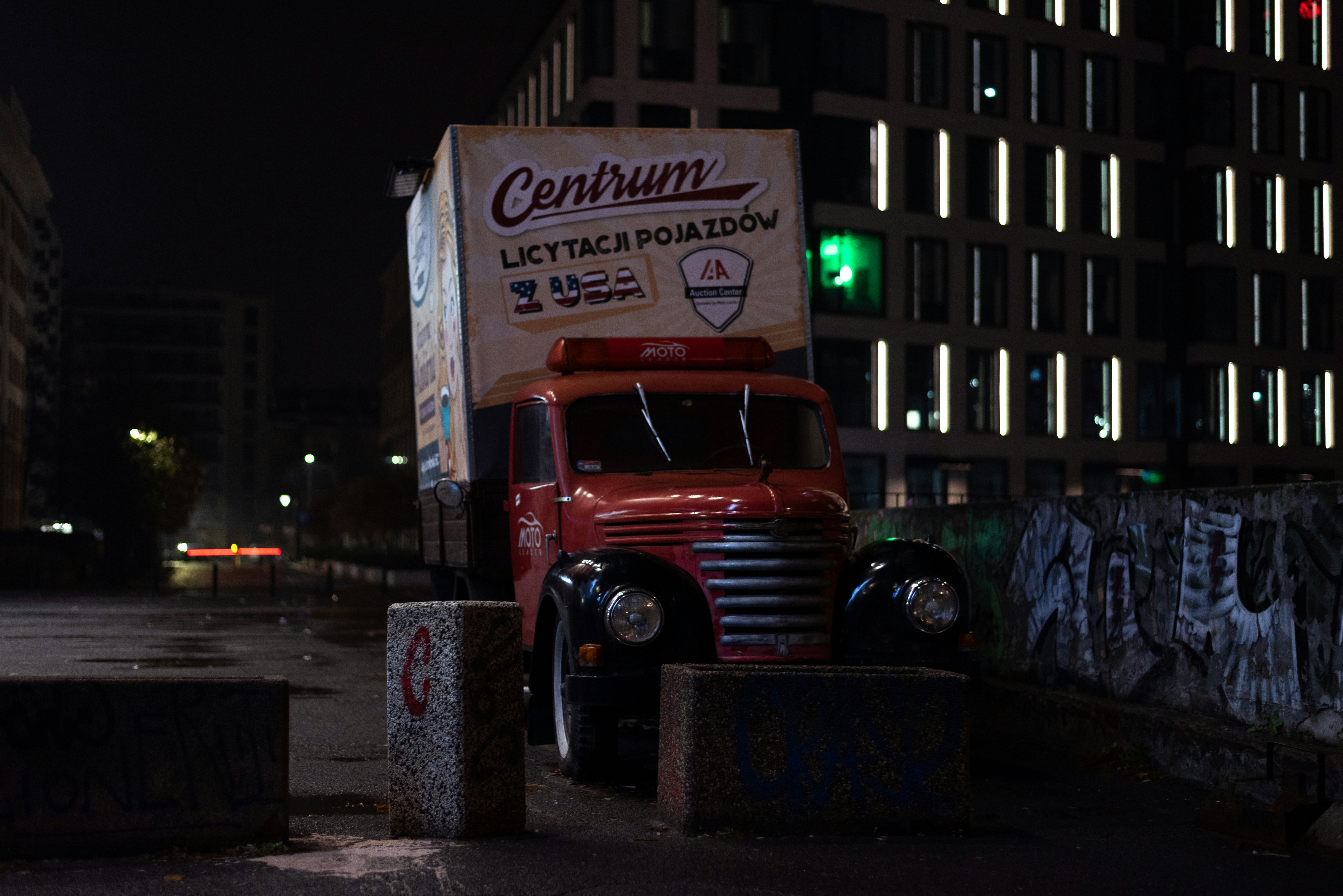 a red truck parked in front of a tall building