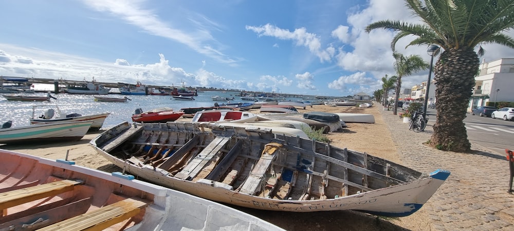 a row of boats sitting on top of a sandy beach