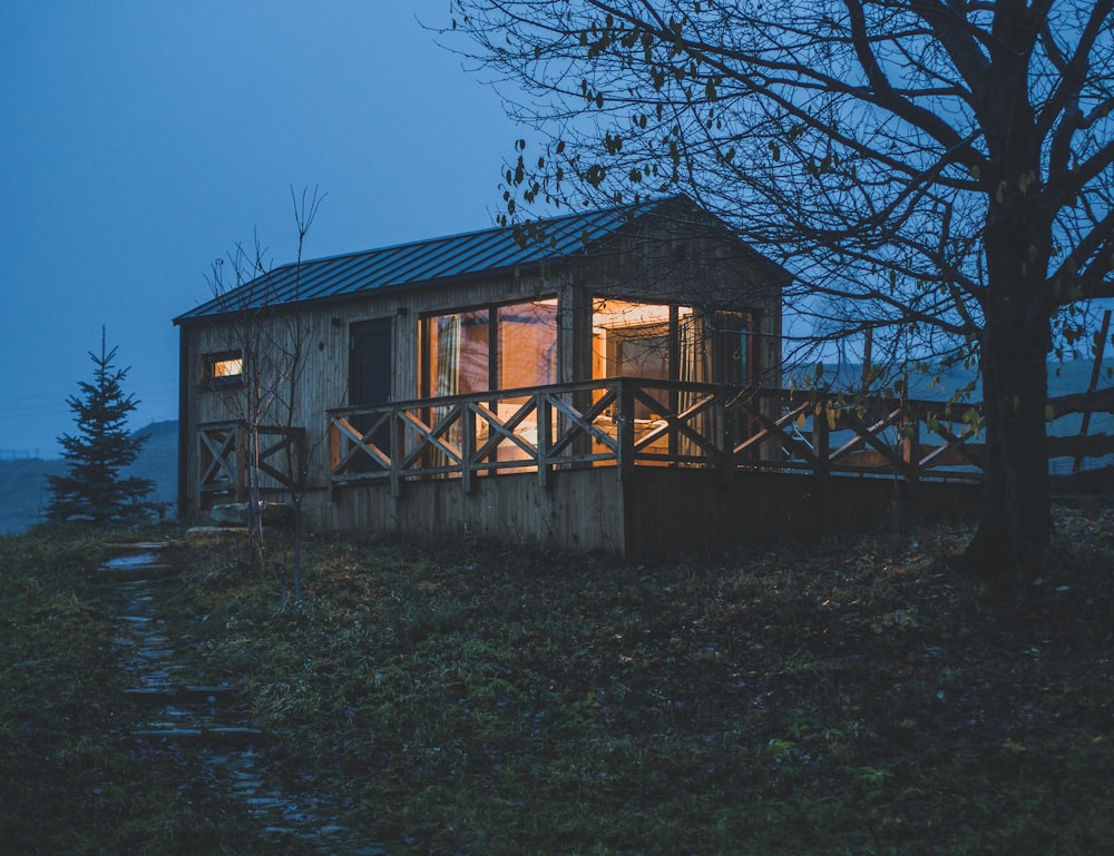 a small cabin sits on a hill at night