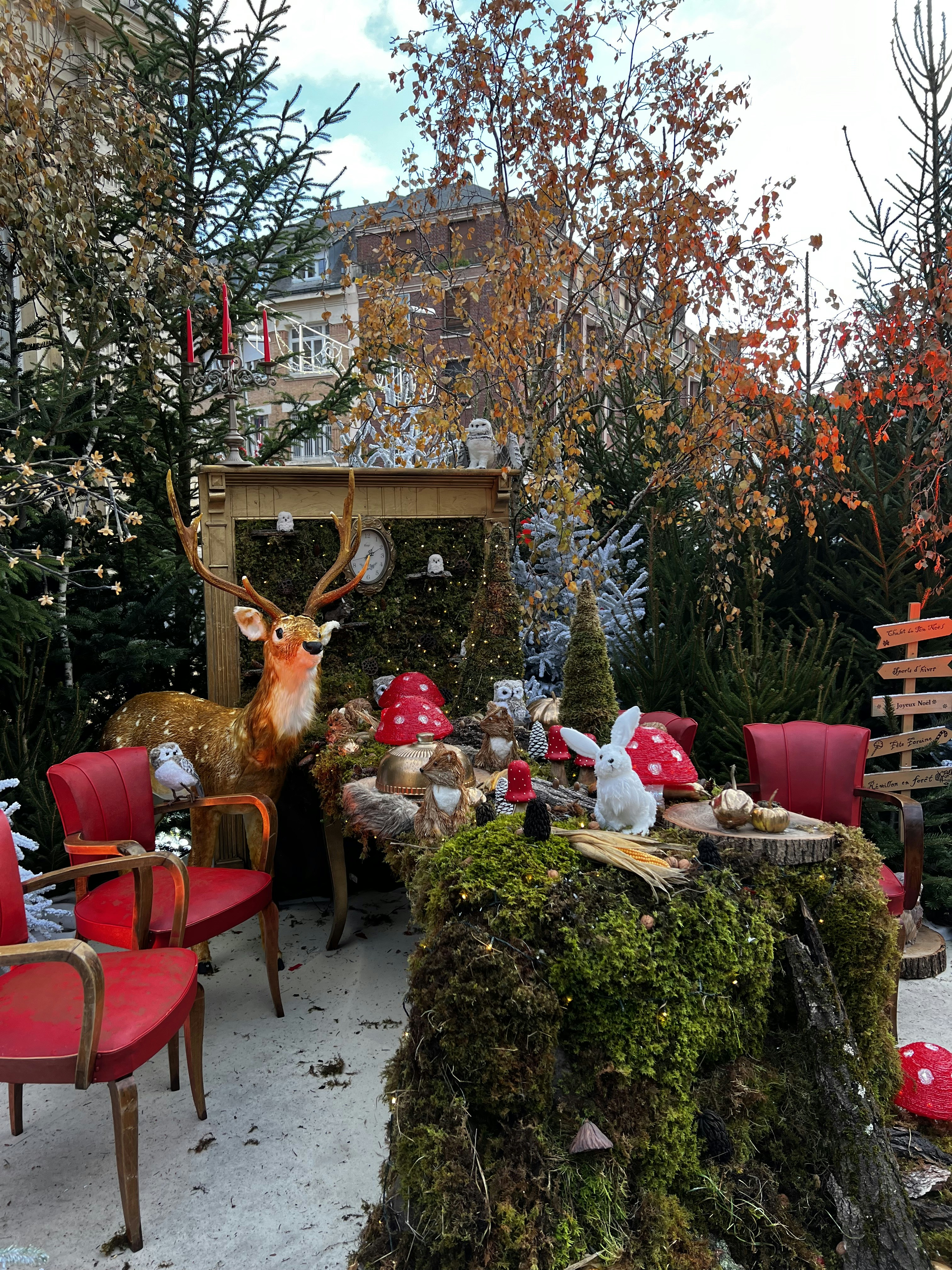 a table with red chairs and a deer statue