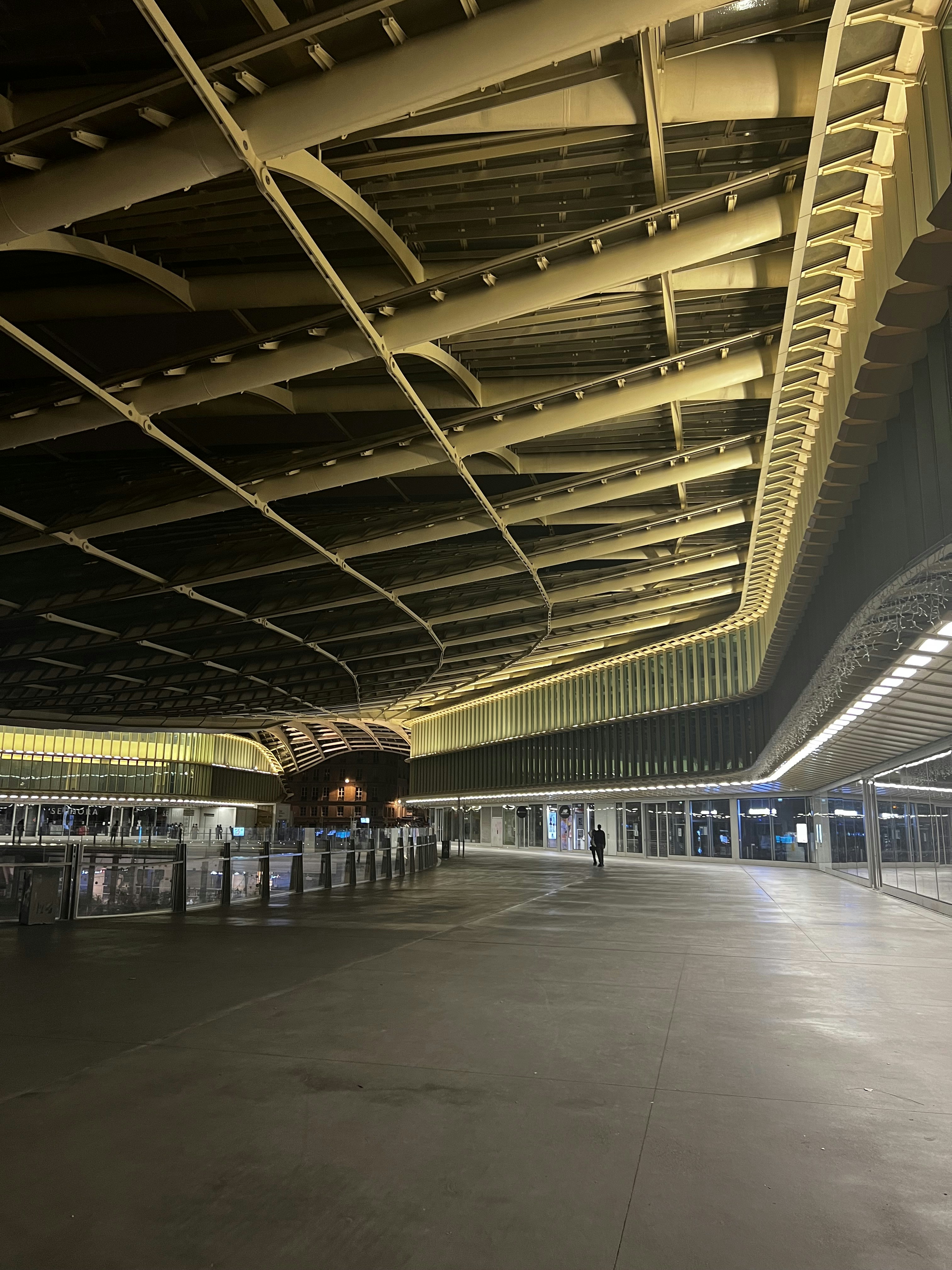 an empty parking garage with a person walking in the distance