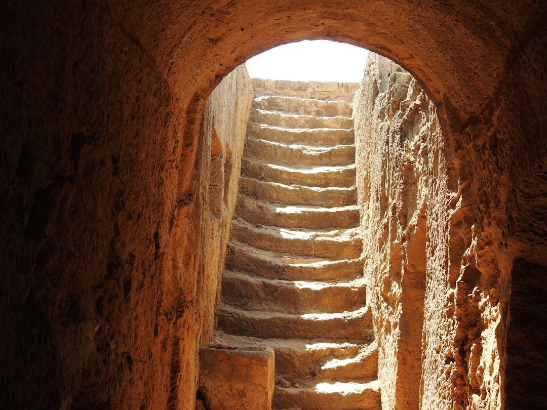 a stone staircase leading to a bright light at the end of a tunnel