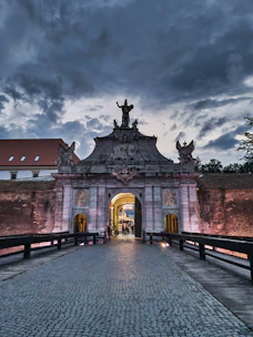 a walkway leading to a building with a statue on top of it