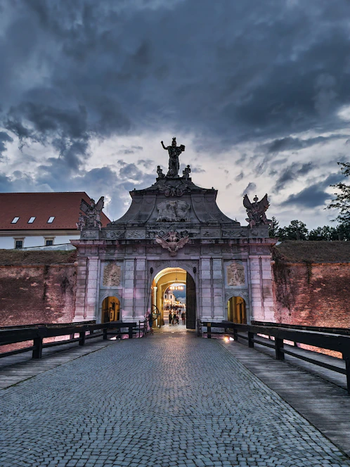 a walkway leading to a building with a statue on top of it