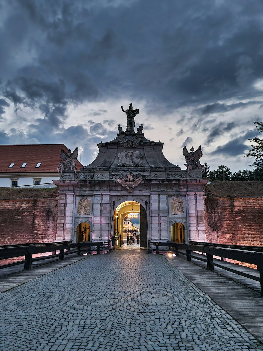 a walkway leading to a building with a statue on top of it