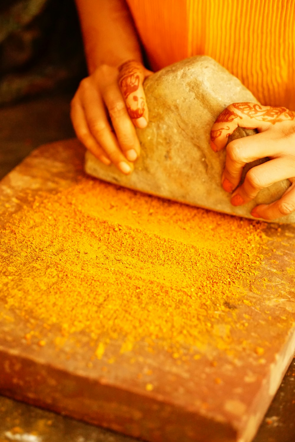 a person holding a piece of bread on top of a cutting board