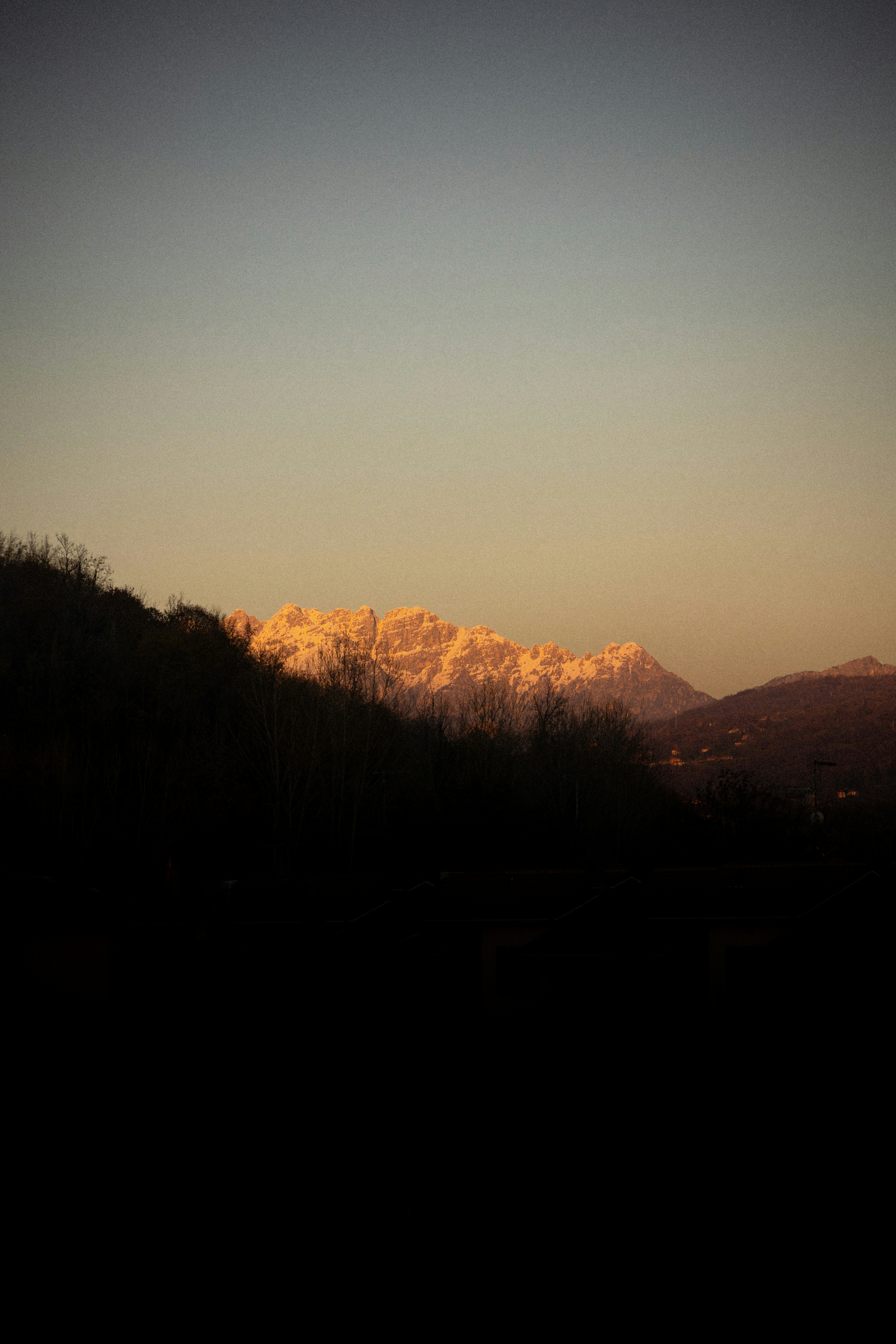 the sun is setting over the mountains in the distance