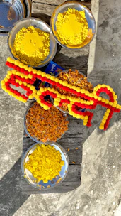 An assortment of ram tilak products arranged artistically against a warm, bhagwa-colored backdrop.