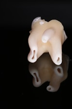 Close-up of a sleek dental implant on a minimalist black background.