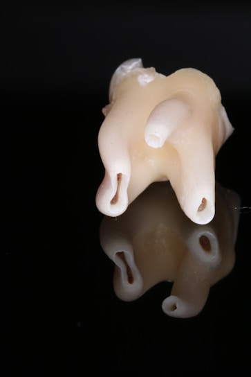 Close-up of a dental implant surface showing its porous texture under bright clinical lighting.