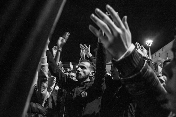 A lively group of diverse people proudly showing their left hands raised in unity.
