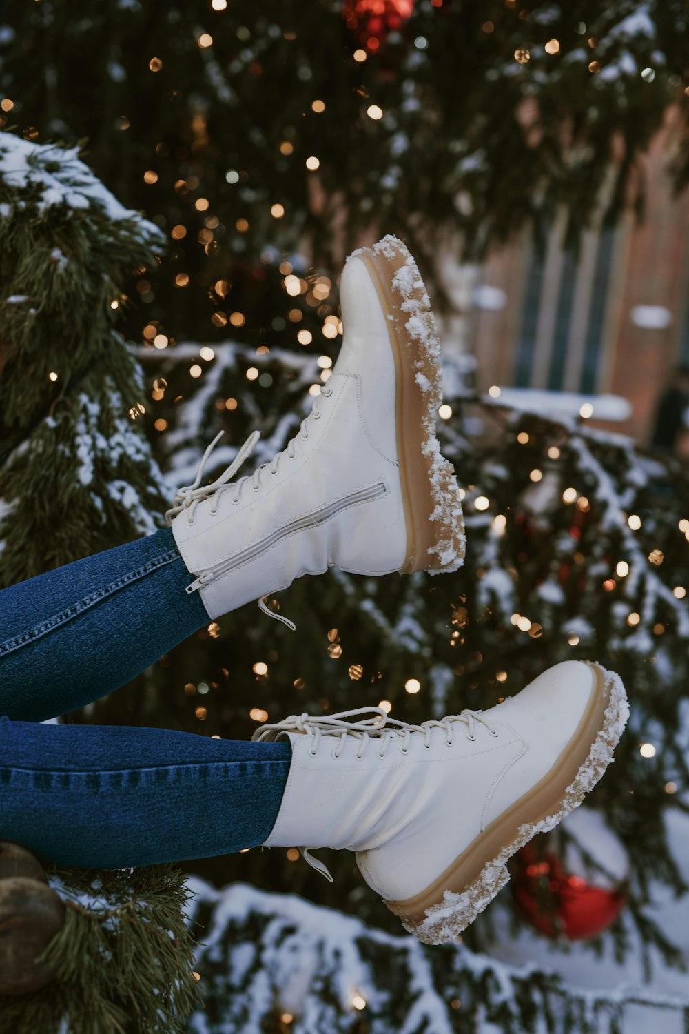 a pair of white boots hanging from a christmas tree