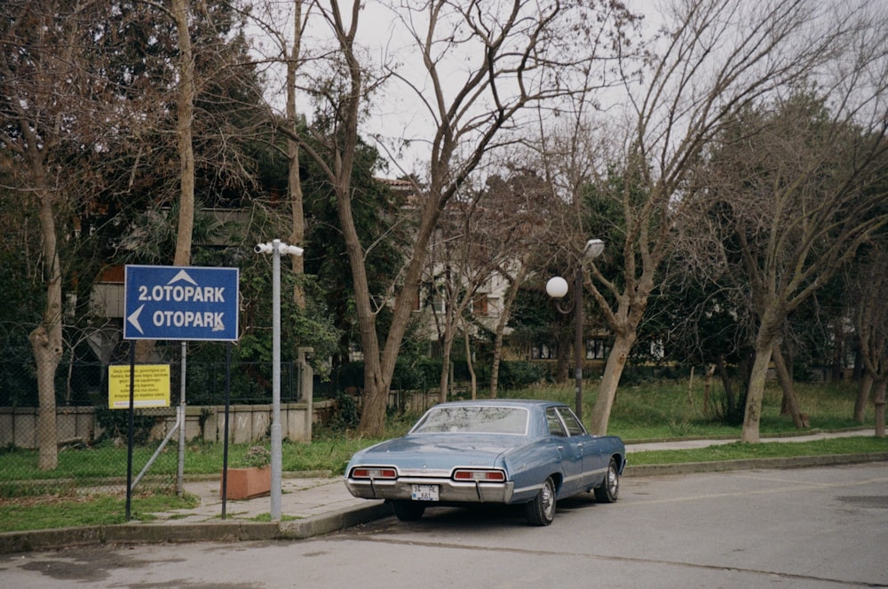 a car parked on the side of a road next to a street sign