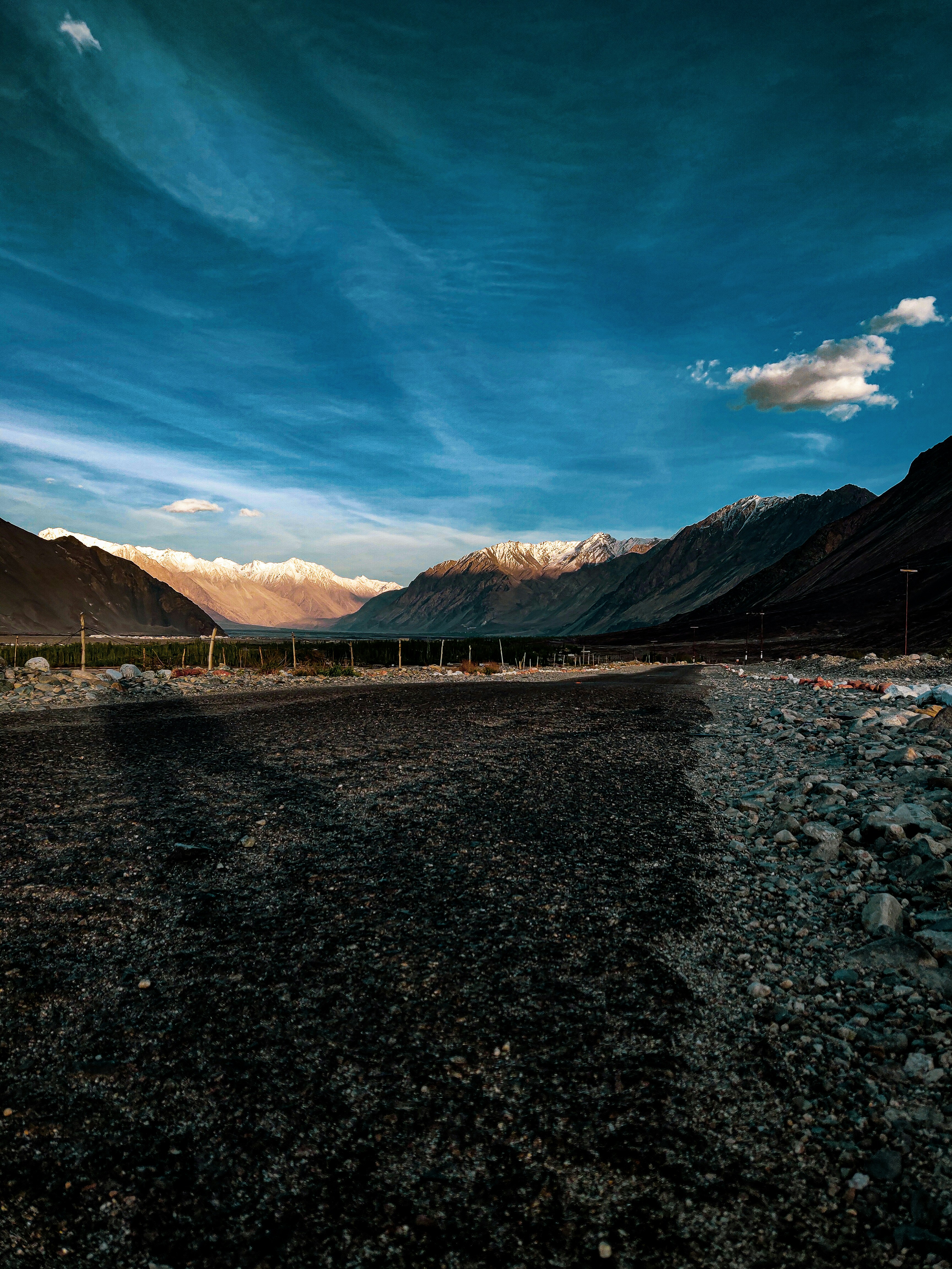 a dirt field with mountains in the background
