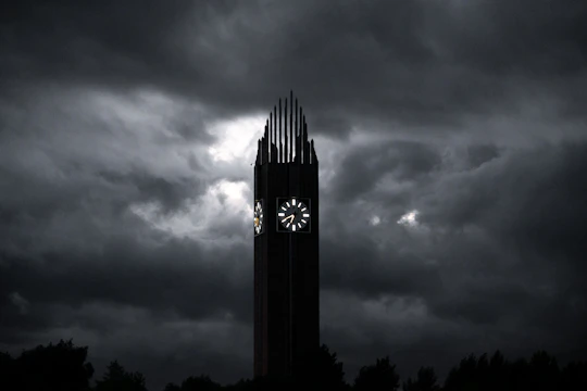 An ultra-realistic image of an ancient clock surrounded by dark clouds and faint golden light piercing through.