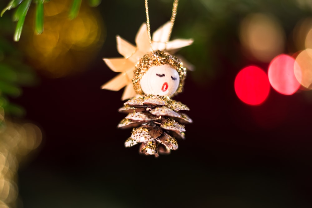 a pine cone ornament hanging from a christmas tree