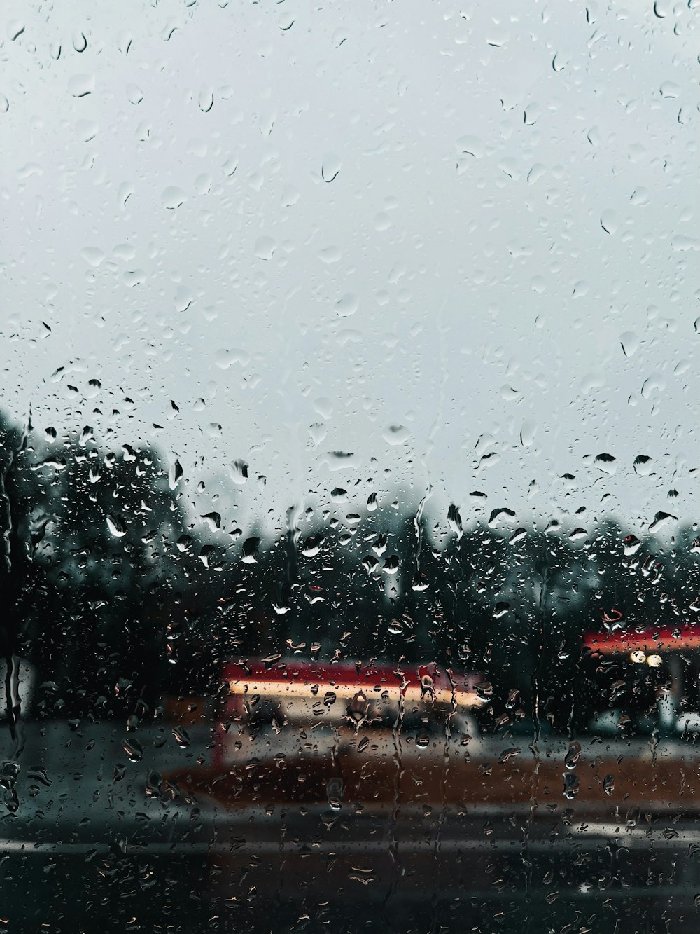 a bus is seen through a rain covered window