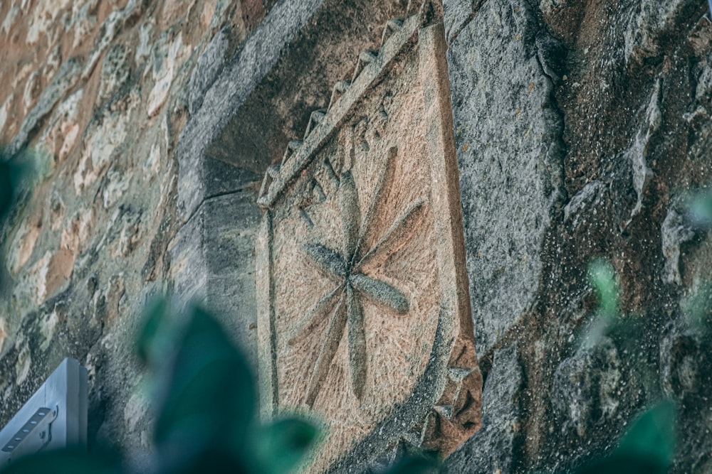 a close up of a clock on a stone wall