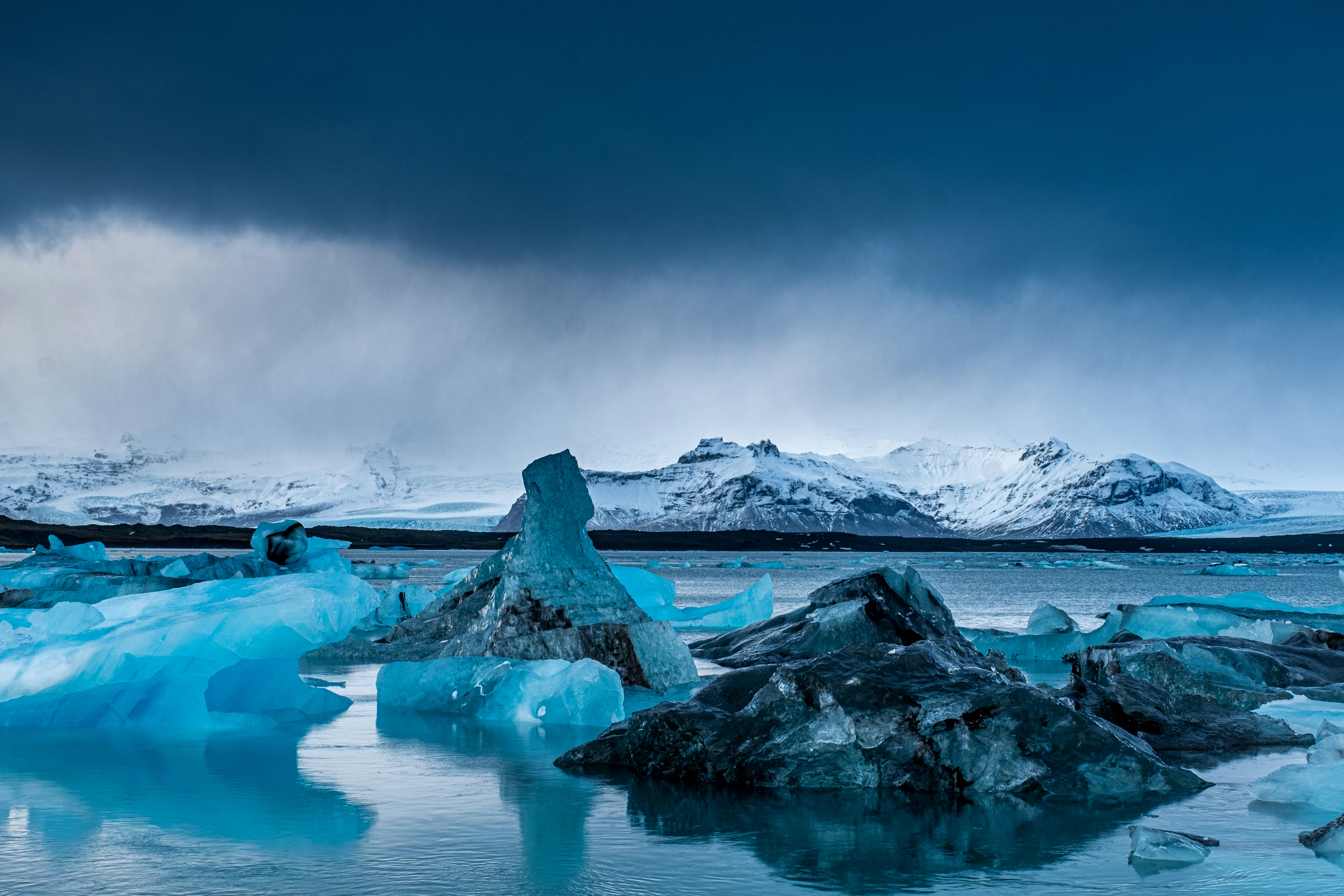 a body of water surrounded by ice and snow covered mountains