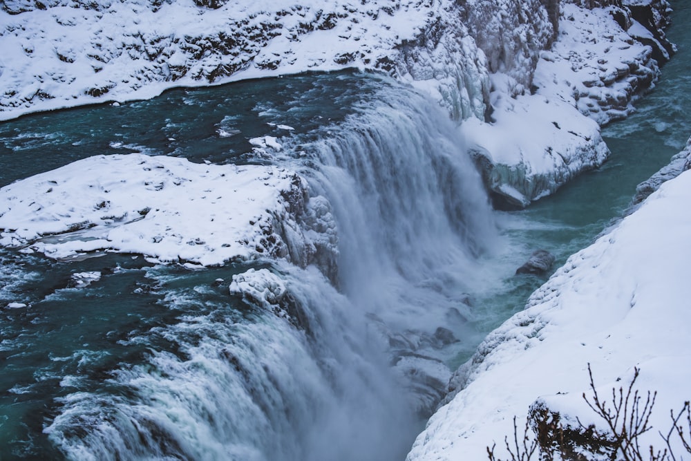 a frozen waterfall with snow on the ground