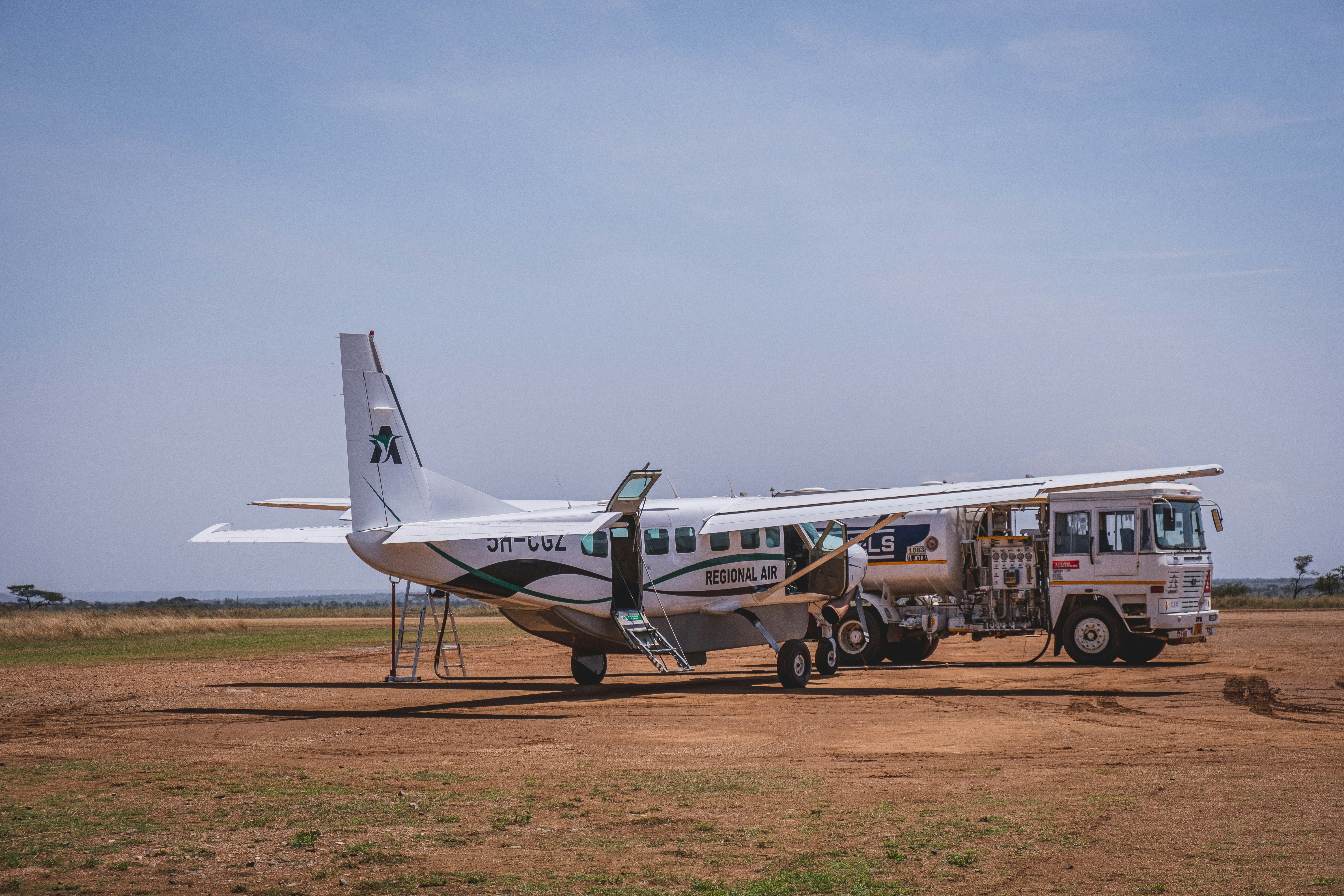 a small plane parked on a dirt field