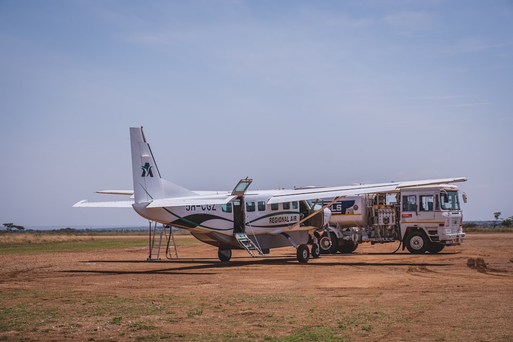 a small plane parked on a dirt field