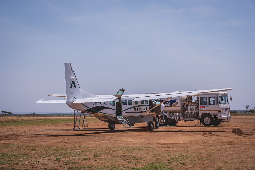 a small plane parked on a dirt field,