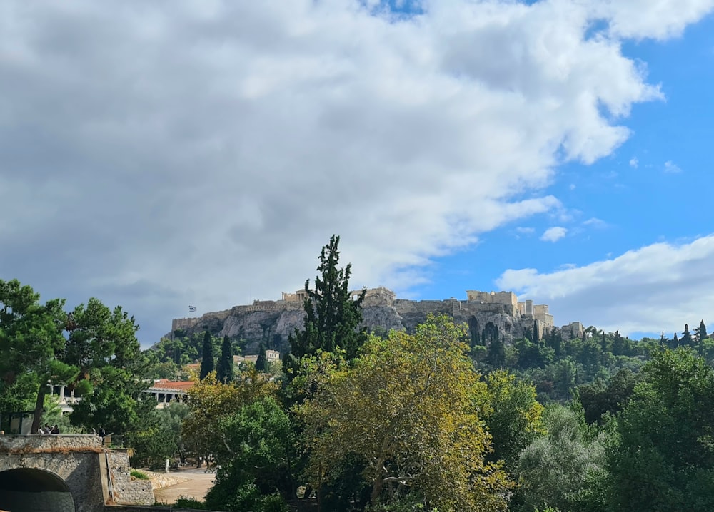 a view of a castle on a hill with trees in the foreground